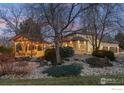 An outdoor pavilion features landscape and stone accents with exterior home view at 9092 Fieldcrest Ln, Longmont, CO 80503