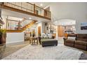 Living room boasts staircase, wood accents, and access to updated kitchen at 9092 Fieldcrest Ln, Longmont, CO 80503