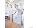 Elegant foyer with a winding staircase featuring hardwood floors and a white banister at 1069 Monarch Way, Superior, CO 80027