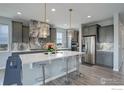 Stunning kitchen with gray cabinets, stainless appliances, quartz countertops, and pendant lighting at 12917 Fox St, Westminster, CO 80234