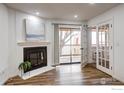Inviting living room with cozy fireplace and access to the balcony through glass paneled doors and beautiful wood floors at 14701 E Tennessee Dr # 132, Aurora, CO 80012