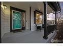 Inviting front porch with a teal door, black trim, and seating area at 1808 Southard St, Erie, CO 80516