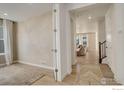 Bright foyer with light wood floors, leading to an open-concept living area with natural light at 1881 Miranda Rd, Erie, CO 80516