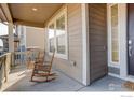 Inviting covered front porch with rocking chairs offers a relaxing outdoor space at 1881 Miranda Rd, Erie, CO 80516