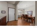 Open dining room featuring hardwood floors, a modern chandelier, and a window view at 1923 Windemere Ln, Erie, CO 80516