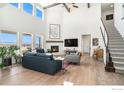 Spacious living room with vaulted ceilings, fireplace, hardwood floors, and an abundance of natural light at 299 Bronco Ct, Berthoud, CO 80513