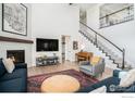 Bright living room with a fireplace, a piano, a staircase and comfortable seating arrangements at 299 Bronco Ct, Berthoud, CO 80513