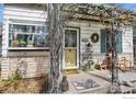Inviting front porch with decorative plants, a yellow door, and unique garden-inspired accents at 305 E Cannon St, Lafayette, CO 80026