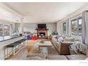 A cozy living room with a fireplace, large windows, and comfortable seating at 3605 Moorhead Ave, Boulder, CO 80305