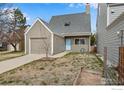 Cozy single Gathering home with an attached garage, blue door and yard with sparse grass at 4866 Brandon Creek Dr, Boulder, CO 80301