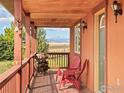 Inviting front porch with cozy seating, offering scenic views of the surrounding landscape and distant mountains at 5139 County Road 38, Platteville, CO 80651