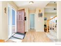 Inviting foyer with hardwood floors, an open wooden front door, and staircase leading to the upper level at 6825 Bugle Ct, Boulder, CO 80301