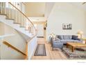 Cozy living room with hardwood flooring and staircase featuring neutral tones and natural light at 6825 Bugle Ct, Boulder, CO 80301