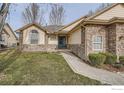 Charming single-story home with stone accents, well-maintained lawn, and inviting blue front door at 7051 Johnson Cir, Niwot, CO 80503