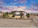 Beautiful rear exterior view of a modern home with elegant landscaping, a split rail fence, and mountain views at 8568 Foxhaven Dr, Longmont, CO 80503