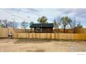 An outbuilding featuring wood paneling and surrounded by a high fence with a 'For Sale' sign at 11488 County Road 20, Fort Lupton, CO 80621