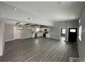 Open-concept living room and kitchen feature wood-look floors and wooden beams on the ceiling at 11488 County Road 20, Fort Lupton, CO 80621