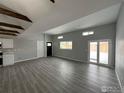 Spacious living room with sliding glass door, wood look floors, and natural lighting at 11488 County Road 20, Fort Lupton, CO 80621