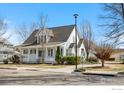 Charming two-story home with a covered porch, neat landscaping, and mature trees on a sunny day at 1228 Allen Ave, Erie, CO 80516