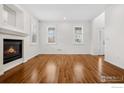Spacious living room boasts gleaming hardwood floors, a cozy fireplace, and large windows at 1228 Allen Ave, Erie, CO 80516
