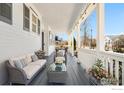 Relaxing porch area with comfortable seating, coffee table, flowers, and neighborhood views at 1228 Allen Ave, Erie, CO 80516