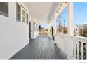 Inviting covered porch featuring string lights and a neutral gray wood floor, perfect for relaxation at 1228 Allen Ave, Erie, CO 80516