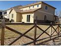 Backyard view featuring a wooden fence, partial stone siding, and sliding glass door to access the home at 14992 E 116Th Pl, Commerce City, CO 80603