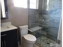 Bathroom featuring a tiled glass shower, white toilet, and vanity with ample counter space at 14992 E 116Th Pl, Commerce City, CO 80603