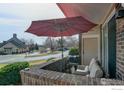 View of patio with comfortable seating under a red umbrella overlooking the street at 1881 Mallard Dr, Superior, CO 80027