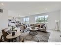 Bright, open-concept living room with modern decor, large windows, and seamless flow into the kitchen at 2711 Crystal Springs Ln, Longmont, CO 80503