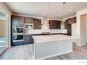 Modern kitchen featuring stainless steel appliances, a spacious island, and dark cabinetry with ample storage at 2718 Crystal Springs Ln, Longmont, CO 80503