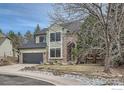 Well-maintained two-story home with stone accents, updated garage door, and a rock-lined flower bed at 325 Peregrine Cir, Broomfield, CO 80020