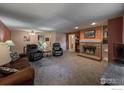 Cozy living room featuring a stone fireplace, plush seating, and ample natural light at 400 Emery St # 103, Longmont, CO 80501