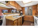 Functional kitchen design with wood walls, window views, and efficient appliances at 8701 Huron St # 106, Thornton, CO 80260