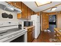 Well-organized kitchen with appliances and wood cabinets, plus a laundry area at 8701 Huron St # 106, Thornton, CO 80260