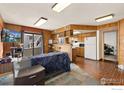 Open-concept living area featuring wooden walls and bar seating connected to kitchen at 8701 Huron St # 106, Thornton, CO 80260