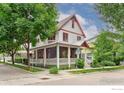 Charming two-story home featuring a welcoming front porch and vibrant red window trim at 906 Confidence Dr, Longmont, CO 80504
