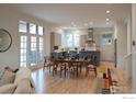 Open concept living space with dining area featuring hardwood floors and ample natural light at 906 Confidence Dr, Longmont, CO 80504