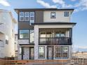 Contemporary three-story home showcasing clean lines and a welcoming second-story balcony at 928 Farrier Ln, Lafayette, CO 80026