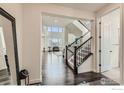 Bright entryway with hardwood floors, stairs, and an open view into the living area at 970 Compass Dr, Erie, CO 80516