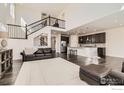 Spacious open floor plan with a view of living area, staircase, and the modern kitchen at 970 Compass Dr, Erie, CO 80516