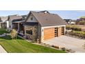 Exterior of home with a two-car garage, stone accents, and well-manicured lawn at 1315 Burt Ave, Berthoud, CO 80513