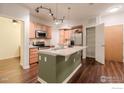 Well-lit kitchen features stainless steel appliances, wooden cabinets, and a stylish island with a marble countertop at 13456 Via Varra # 114, Broomfield, CO 80020