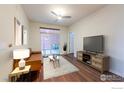 Cozy living room featuring natural lighting, a modern ceiling fan, a stylish sofa, and a large TV at 13456 Via Varra # 114, Broomfield, CO 80020