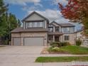 Inviting two-story home with a stone and siding exterior, a three-car garage, and a landscaped front yard at 14181 Whitney Cir, Broomfield, CO 80023