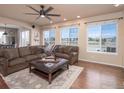 Spacious living room featuring a cozy sectional sofa, large windows, and an elegant ceiling fan at 14181 Whitney Cir, Broomfield, CO 80023