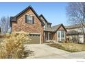 Charming two-story brick home with a well-maintained lawn and inviting front porch at 1526 Chukar Dr, Longmont, CO 80504