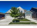 Inviting home with a well-manicured lawn and dual garages offering ample parking and storage at 2407 Tyrrhenian Cir, Longmont, CO 80504