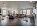 Expansive living room with hardwood floors, fireplace and large windows and open to dining area at 2407 Tyrrhenian Cir, Longmont, CO 80504