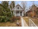 View of the house and front yard. The house has gray siding, a covered front porch, and a sidewalk at 3056 W 34Th Ave, Denver, CO 80211